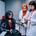 Estudantes de medicina praticam a aferição da pressão arterial em ambiente universitário.